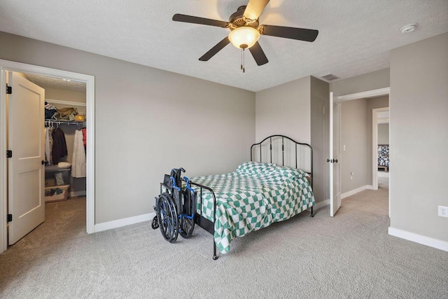 2306 Larkspur Dr, Troy, OH 45373 - carpeted bedroom featuring a walk in closet, a textured ceiling, ceiling fan, and a closet