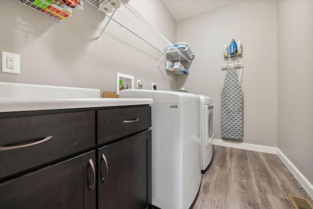 2306 Larkspur Dr, Troy, OH 45373 - washroom featuring wood finished floors, cabinet space, and independent washer and dryer
