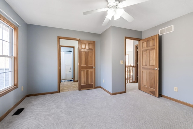 unfurnished bedroom featuring light carpet, visible vents, and multiple windows