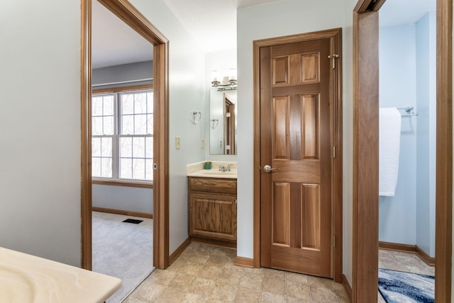 bathroom featuring vanity, visible vents, and baseboards