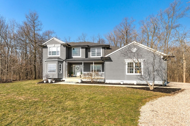 traditional home with a front yard, covered porch, and a shingled roof