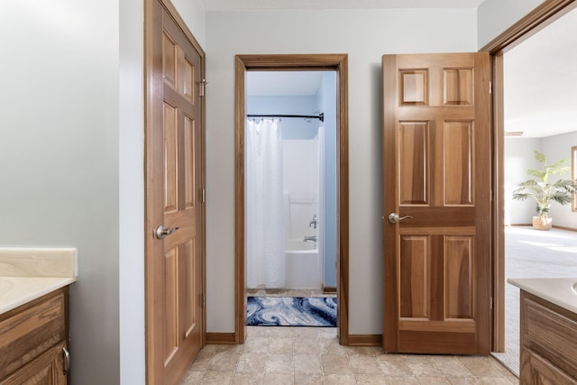 full bathroom with shower / bathtub combination with curtain, baseboards, and vanity