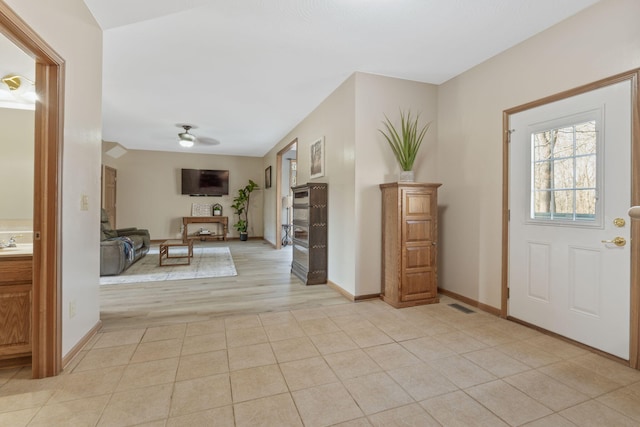 entrance foyer with light tile patterned floors, visible vents, baseboards, and a ceiling fan