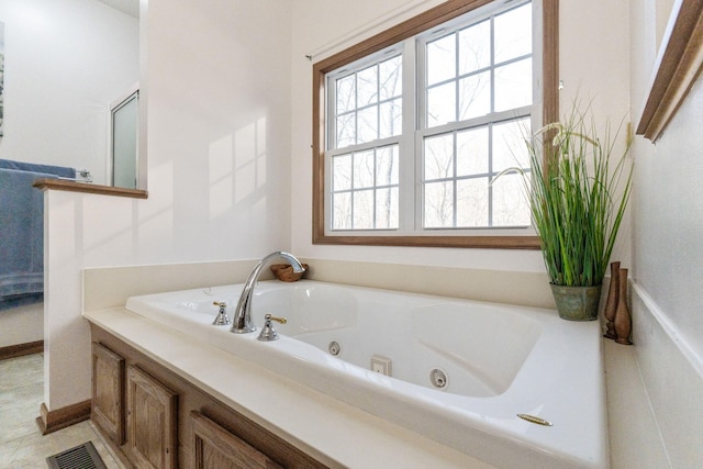 bathroom with visible vents and a whirlpool tub