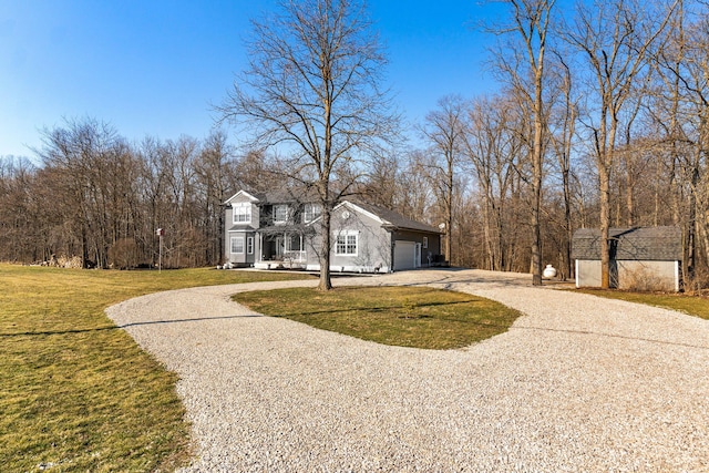 view of front of house featuring an attached garage, gravel driveway, and a front yard