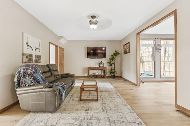 living room with visible vents, baseboards, a ceiling fan, and wood finished floors