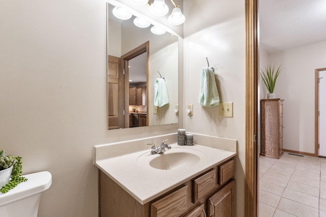 half bathroom featuring tile patterned floors, toilet, and vanity