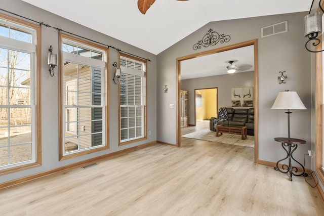 entrance foyer with visible vents, lofted ceiling, a ceiling fan, and wood finished floors