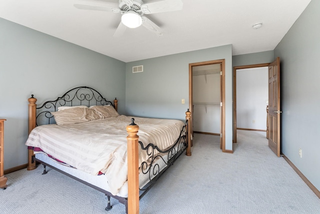 bedroom with visible vents, light colored carpet, baseboards, and ceiling fan