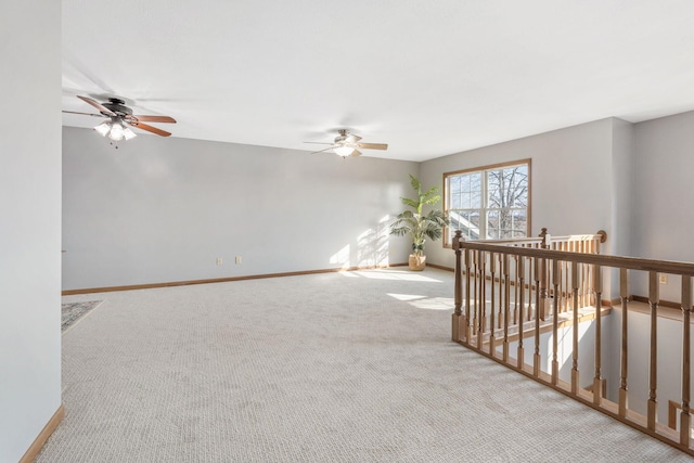 empty room with carpet flooring, baseboards, and ceiling fan