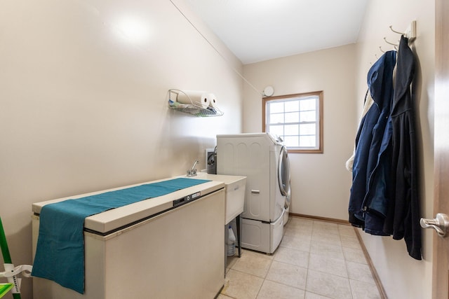 washroom with baseboards, light tile patterned flooring, and laundry area