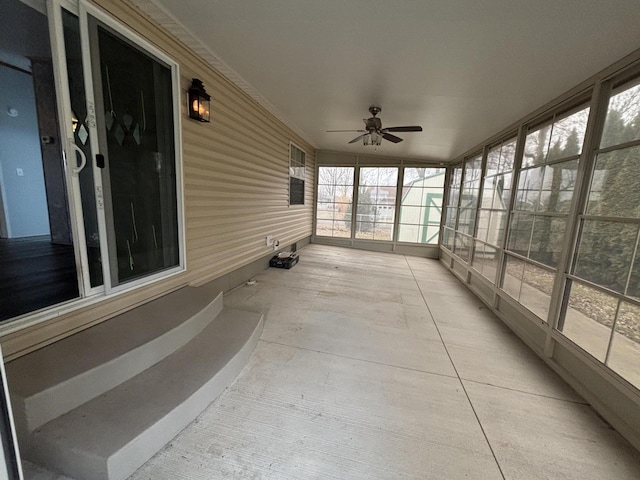 unfurnished sunroom with a ceiling fan