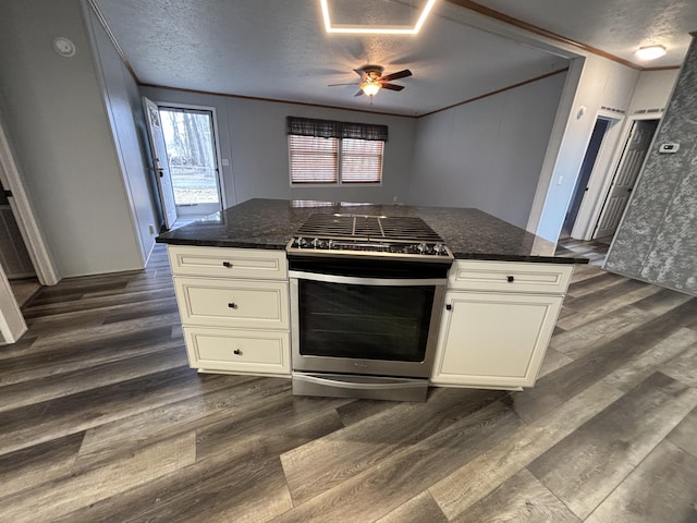 kitchen featuring stainless steel range with gas cooktop, dark wood-style flooring, ornamental molding, white cabinetry, and a textured ceiling