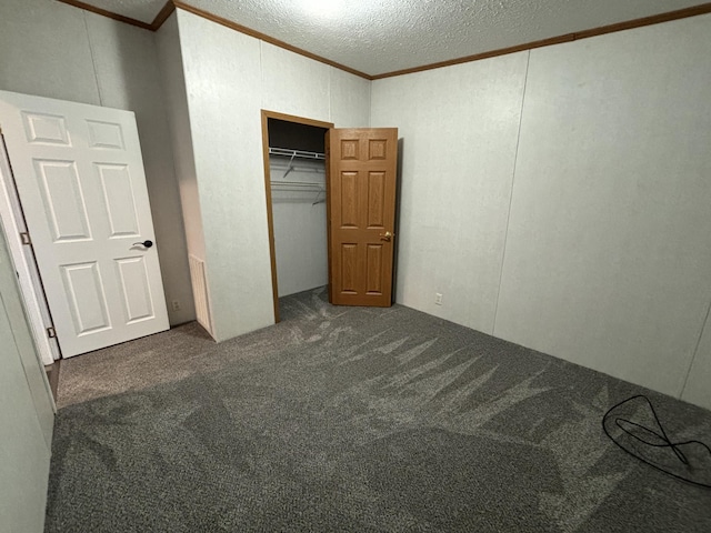 unfurnished bedroom with a closet, carpet flooring, crown molding, and a textured ceiling