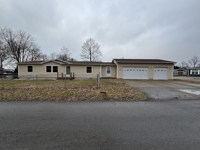 single story home featuring a fenced front yard and a garage