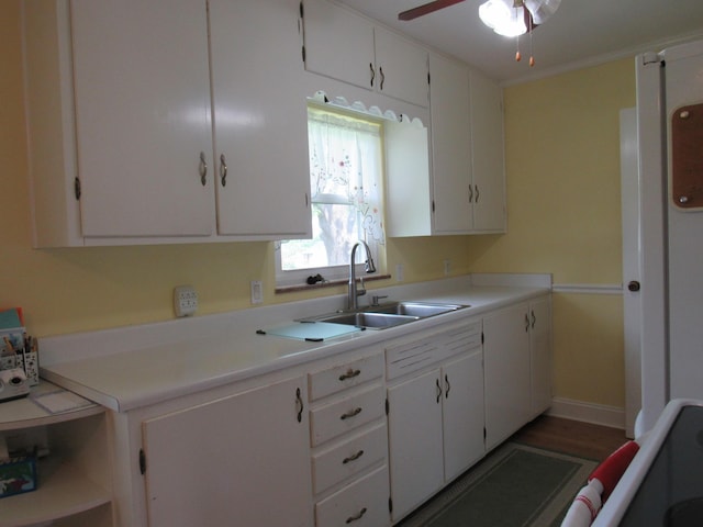 kitchen with a sink, a ceiling fan, white cabinetry, and light countertops