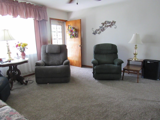 carpeted living area featuring ceiling fan