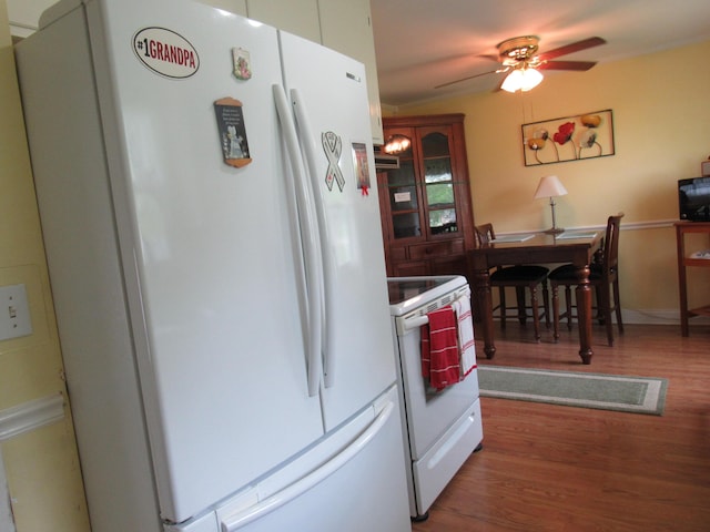 kitchen featuring white appliances, wood finished floors, and ceiling fan