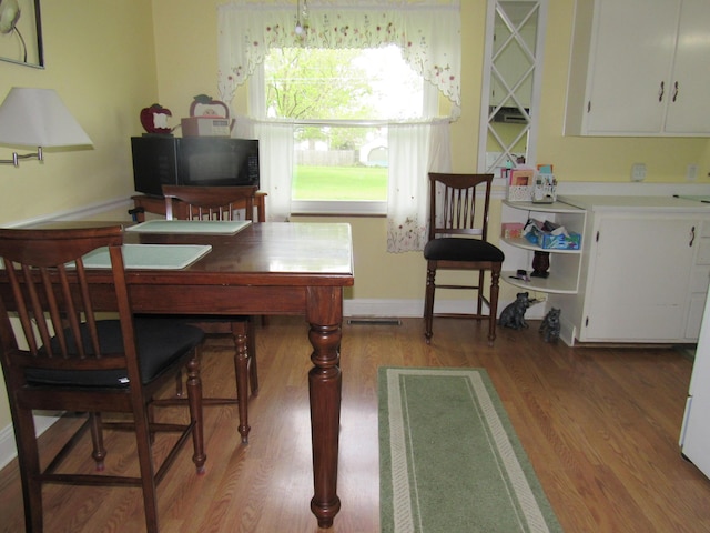 dining room featuring light wood-type flooring, baseboards, and an office area