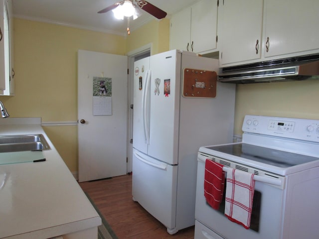 kitchen with white appliances, under cabinet range hood, a sink, crown molding, and wood finished floors