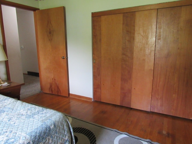 bedroom with wood finished floors and a closet
