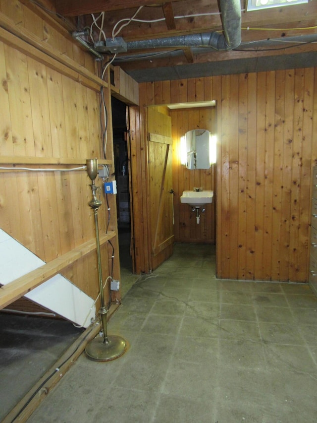 corridor featuring a sink and wood walls