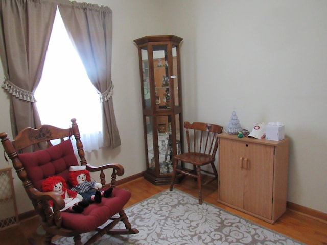 living area featuring light wood-type flooring and baseboards