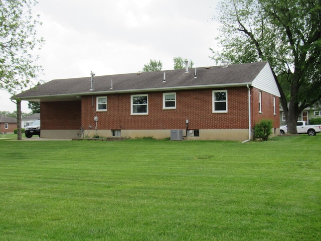 rear view of property with brick siding and a yard