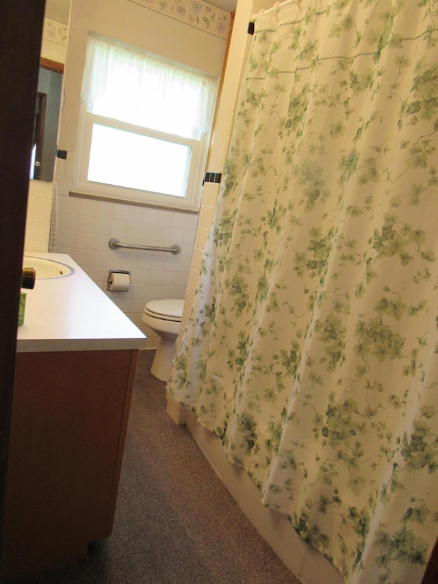full bathroom featuring tile walls, vanity, and toilet