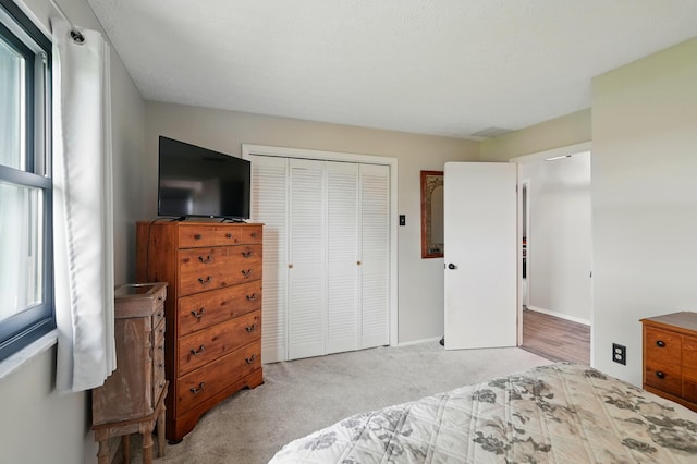 bedroom featuring a closet, carpet, baseboards, and multiple windows