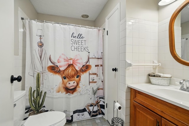 full bathroom with toilet, tile walls, a shower with shower curtain, and vanity