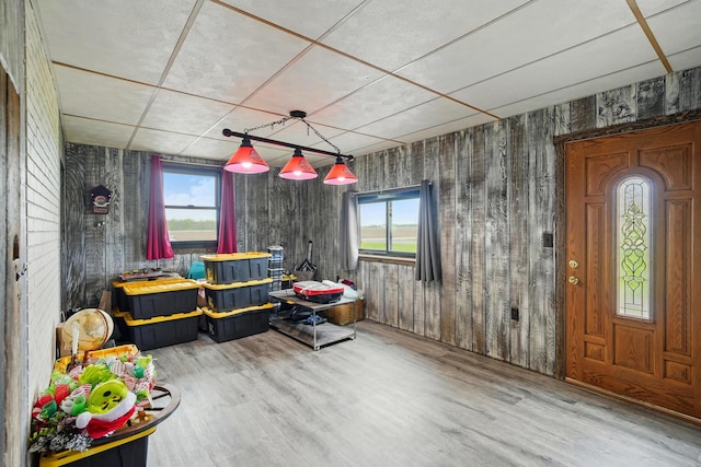 playroom featuring a drop ceiling, wood finished floors, and a wealth of natural light