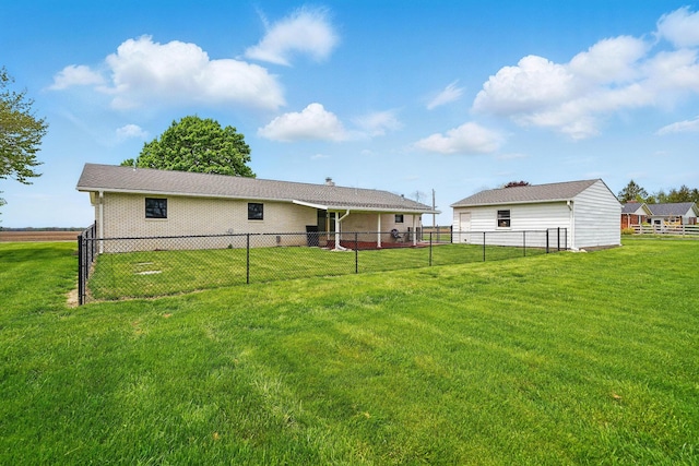 rear view of house featuring brick siding, fence, and a yard