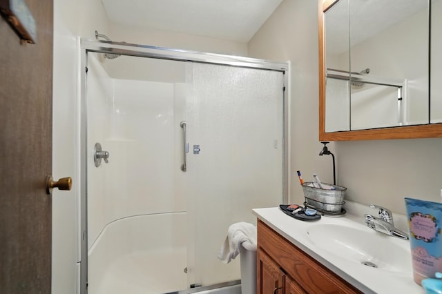 bathroom with vanity and a shower with door