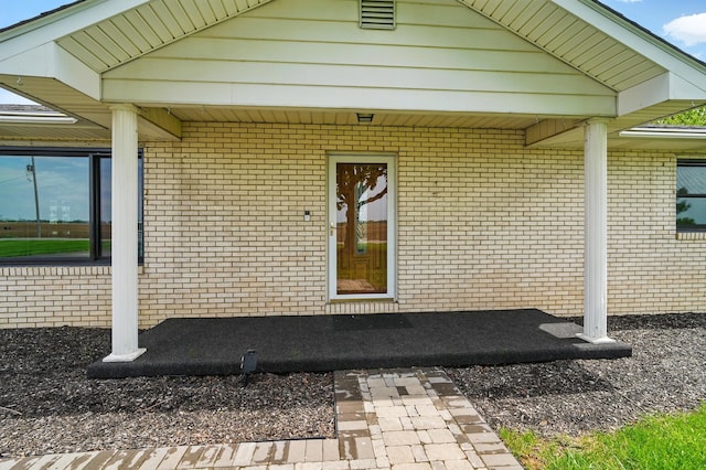 view of exterior entry featuring brick siding