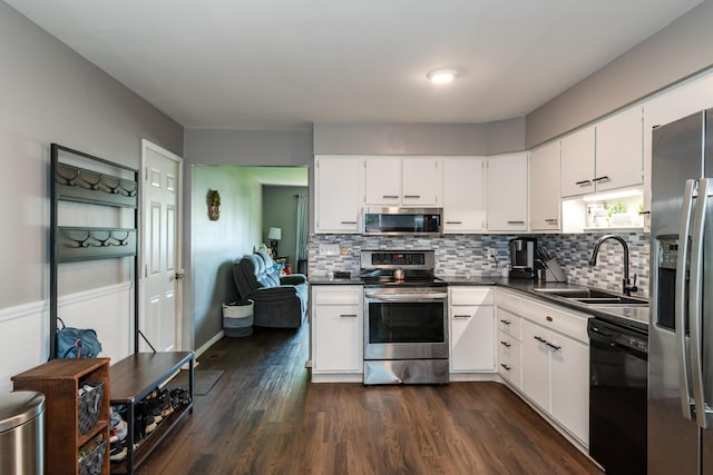 730 Maplecrest Dr, Troy, OH 45373 - kitchen featuring stainless steel appliances, a sink, dark countertops, backsplash, and white cabinetry