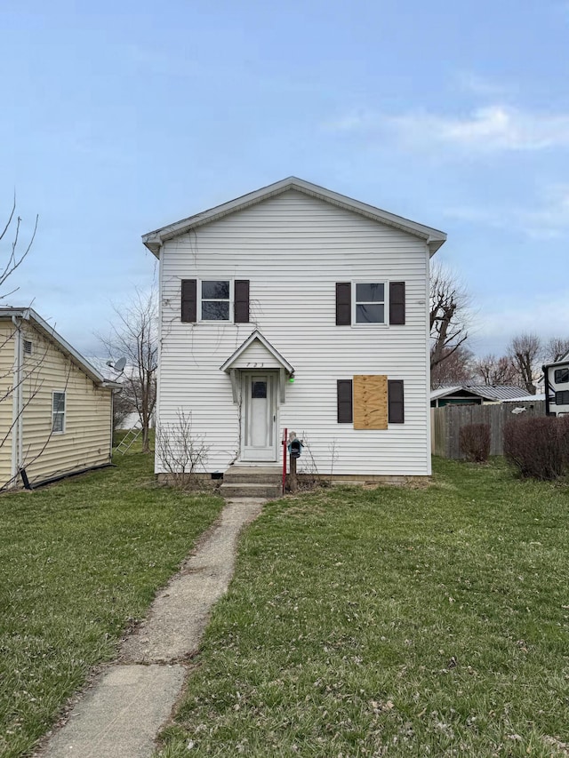 traditional-style house with a front lawn and entry steps