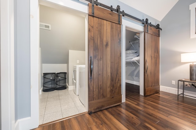 7933 Hickory Ave, Russells Point, OH 43348 - corridor featuring a barn door, lofted ceiling, baseboards, washer and dryer, and wood finished floors