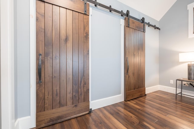 7933 Hickory Ave, Russells Point, OH 43348 - entryway featuring a barn door, baseboards, wood finished floors, and vaulted ceiling