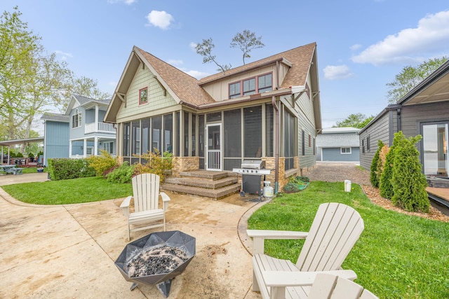 7933 Hickory Ave, Russells Point, OH 43348 - back of house featuring a sunroom, an outdoor fire pit, roof with shingles, a patio area, and a yard