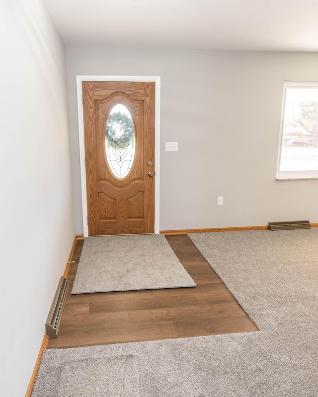 entryway with a wealth of natural light, baseboards, and wood finished floors