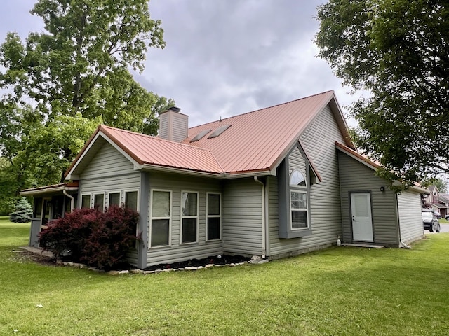 224 Oakcrest Ct, Russells Point, OH 43348 - back of house featuring a chimney, a yard, and metal roof
