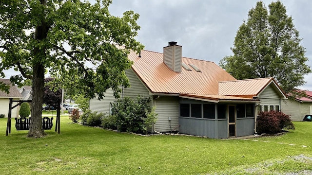 224 Oakcrest Ct, Russells Point, OH 43348 - back of house with a chimney, a lawn, metal roof, and a sunroom