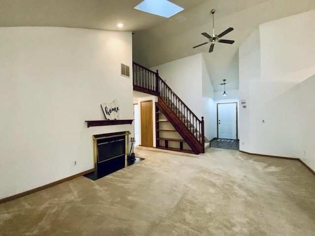224 Oakcrest Ct, Russells Point, OH 43348 - unfurnished living room featuring high vaulted ceiling, baseboards, stairway, a fireplace with flush hearth, and carpet