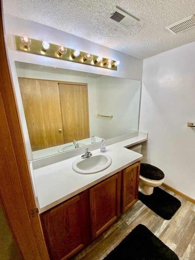 224 Oakcrest Ct, Russells Point, OH 43348 - bathroom featuring vanity, wood finished floors, a textured ceiling, toilet, and baseboards