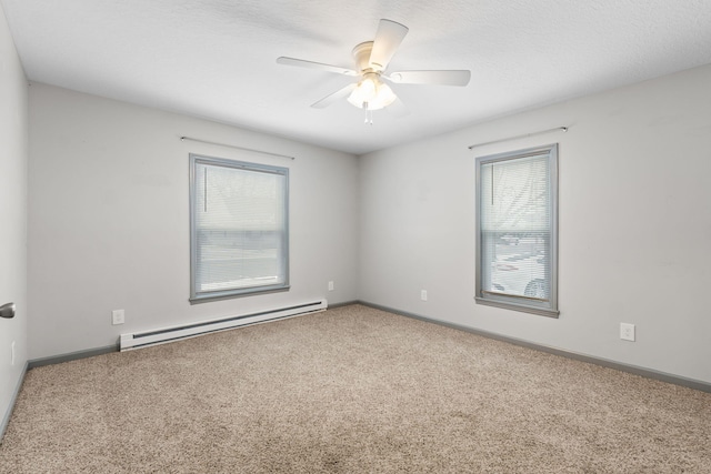 carpeted spare room featuring a baseboard heating unit, a ceiling fan, baseboards, and a textured ceiling