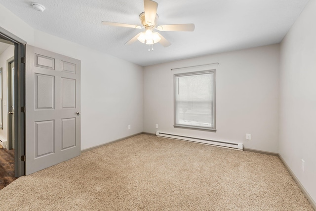 spare room featuring a ceiling fan, baseboards, carpet floors, a textured ceiling, and a baseboard heating unit