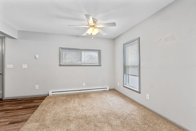 unfurnished room with a baseboard heating unit, baseboards, a textured ceiling, and a ceiling fan