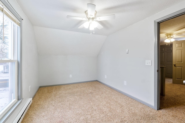 additional living space featuring carpet floors, baseboard heating, ceiling fan, and vaulted ceiling