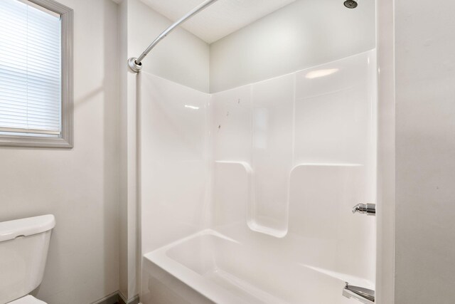 bathroom with shower / washtub combination and toilet